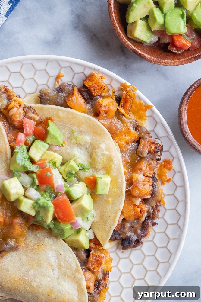 Close-up photo of a single roasted sweet potato taco with black beans, showing the crispy tortilla and delicious filling.