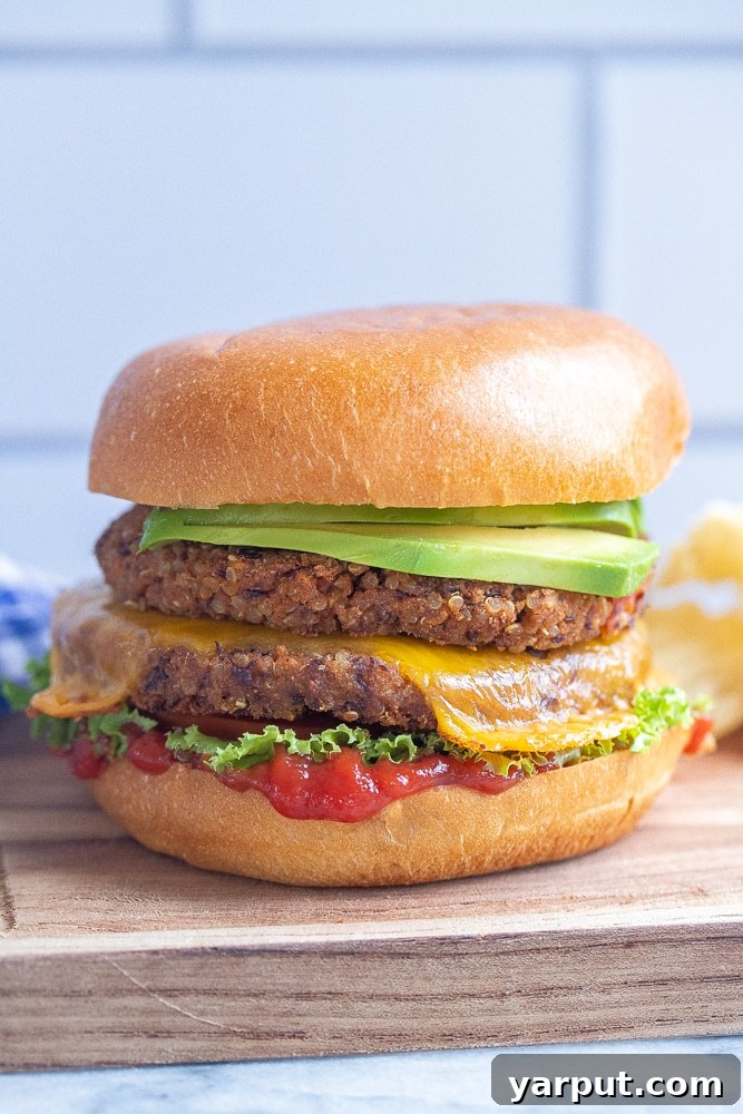 Two homemade black bean smash burgers on buns with fresh lettuce, tomato, and onion.