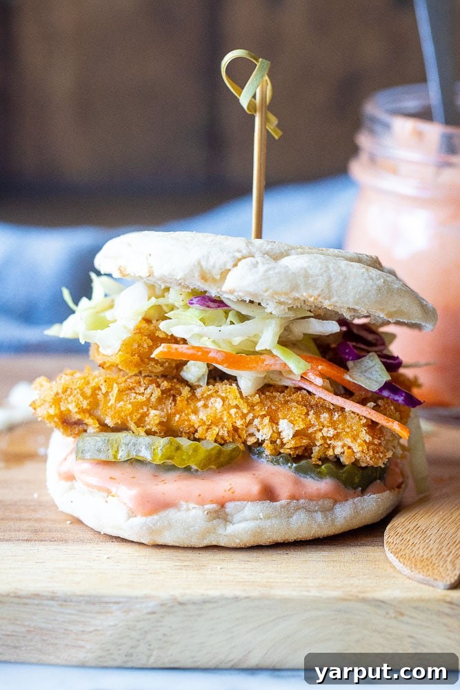A hearty Crispy Tofu Sandwich with fresh toppings, served on a bun, showcasing a delicious vegetarian dinner option.