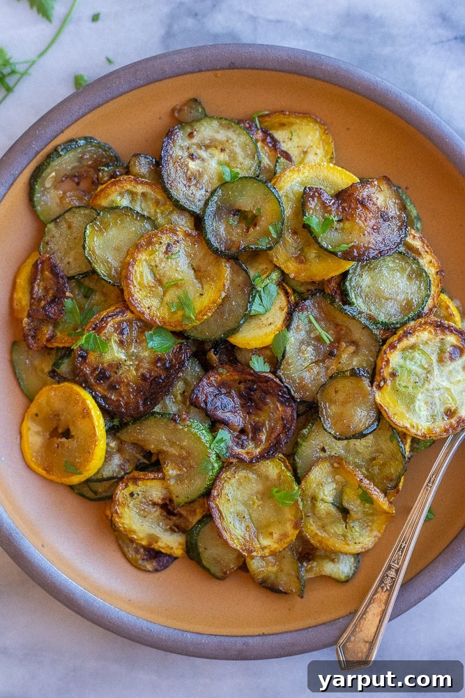 Skillet Caramelized Summer Squash 5 Plate full of perfectly pan-fried summer squash and zucchini, garnished with fresh chopped parsley.