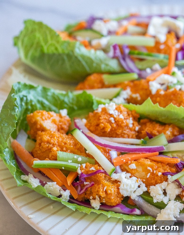 Fiery Tofu Lettuce Cups 2 Close-up of a perfectly assembled crispy buffalo tofu lettuce wrap, generously loaded with fresh toppings, showcasing its vibrant colors and inviting texture.