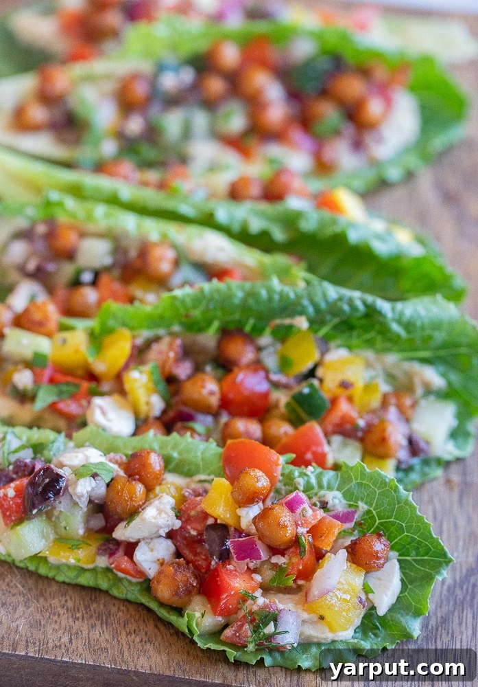 Vibrant Greek Hummus Lettuce Wraps 5 A single Greek salad lettuce wrap, beautifully presented, showcasing its generous filling of colorful vegetables and creamy hummus, ready for a healthy and satisfying bite.