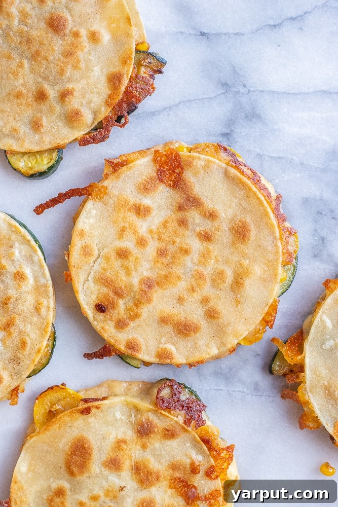 Golden Zucchini and Sweet Corn Quesadillas 5 Close-up shot of perfectly browned and crispy corn and zucchini quesadillas resting on a wooden cutting board, ready for slicing.