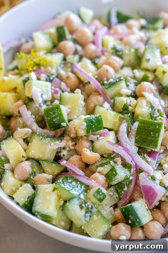 Close up of creamy feta cucumber salad in a bowl, showing the texture and vibrant colors