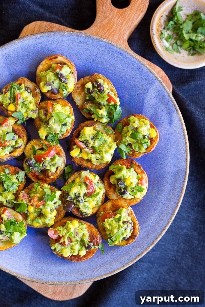 Crispy Roasted Potato Cups with Loaded Guacamole 5 Delicious Roasted Potato Cups with Loaded Guacamole on a blue ceramic plate