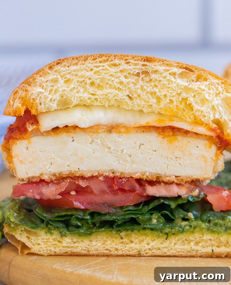 Veggie Chick'n Parm Sandwiches 5 A vegetarian chicken parmesan sandwich, perfectly cut in half to reveal the layers of crispy tofu, rich marinara, and melted mozzarella inside a brioche bun