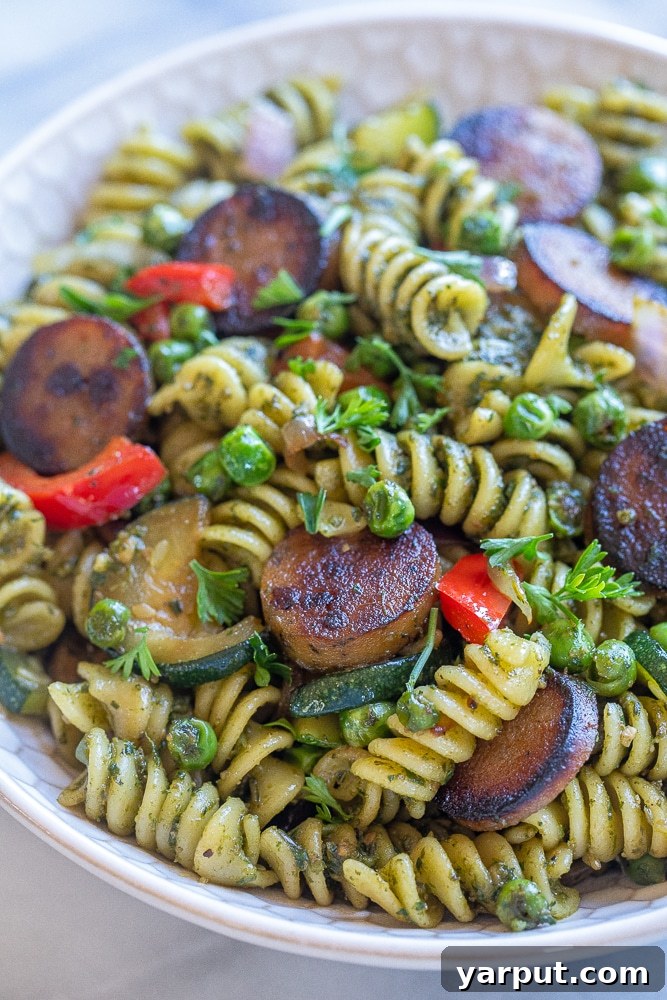 Crispy Sausage Pesto Pasta with Vibrant Vegetables 7 A tempting close-up shot of the crispy plant-based sausage pesto pasta with vegetables, highlighting the delicious texture and fresh ingredients.