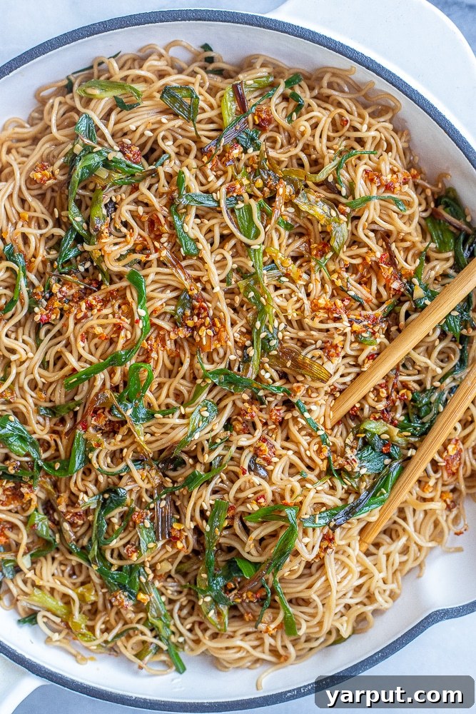 A bowl of Scallion Soy Noodles, topped with fresh green scallions and sesame seeds.