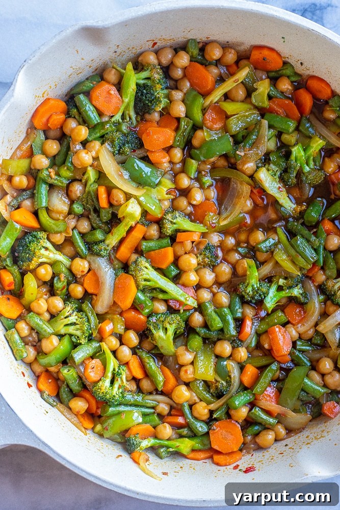 A bowl filled with chili garlic vegetables and chickpeas, generously coated in the rich, glossy sauce, ready to be served.