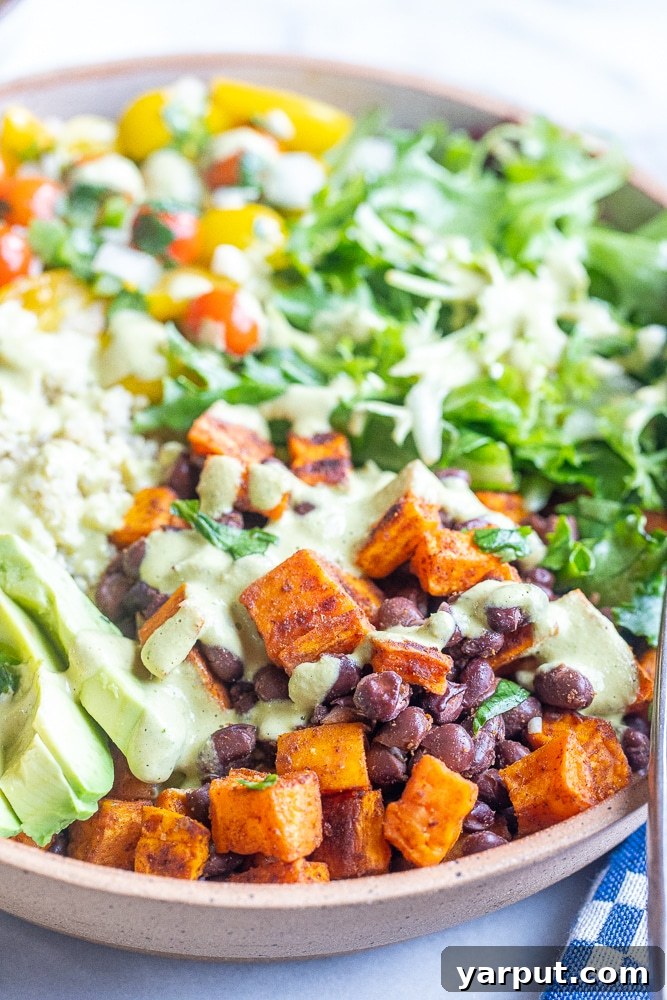 Vibrant Sweet Potato Quinoa Bowls with Green Chile Tahini 6 Close up of perfectly roasted sweet potatoes and black beans nestled in a bowl with fluffy quinoa, ready for the sauce.