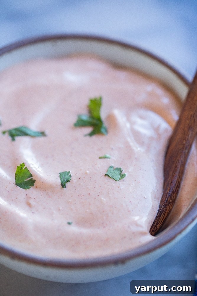 Creamy Zesty Fish Taco Sauce 7 Close-up shot of a bowl of creamy fish taco sauce, emphasizing its rich texture and color.
