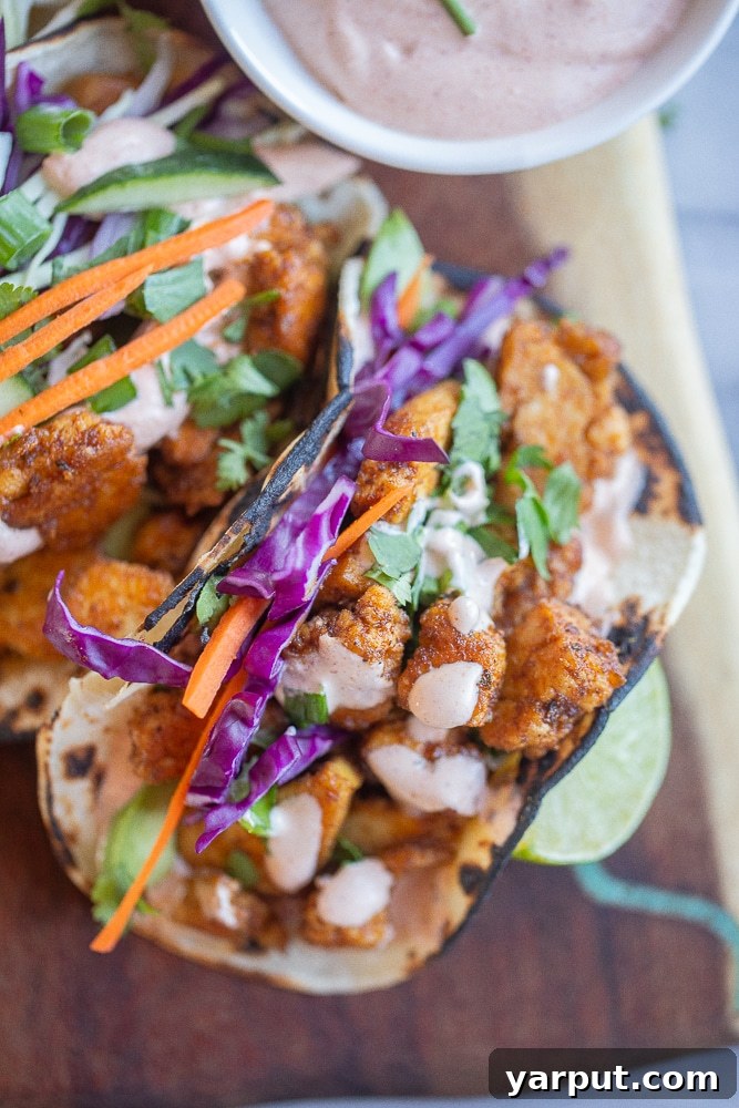 close up of a blackened tofu taco topped with fish taco sauce