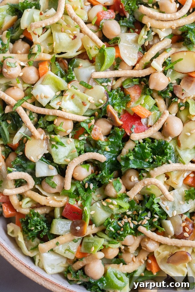 Close-up of Asian kale and cabbage salad with peanut dressing in a bowl, showing the vibrant colors and textures.