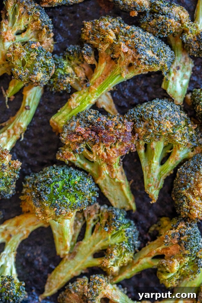Sheet pan filled with golden-brown tahini roasted broccoli, fresh out of the oven, highlighting its crispy texture.