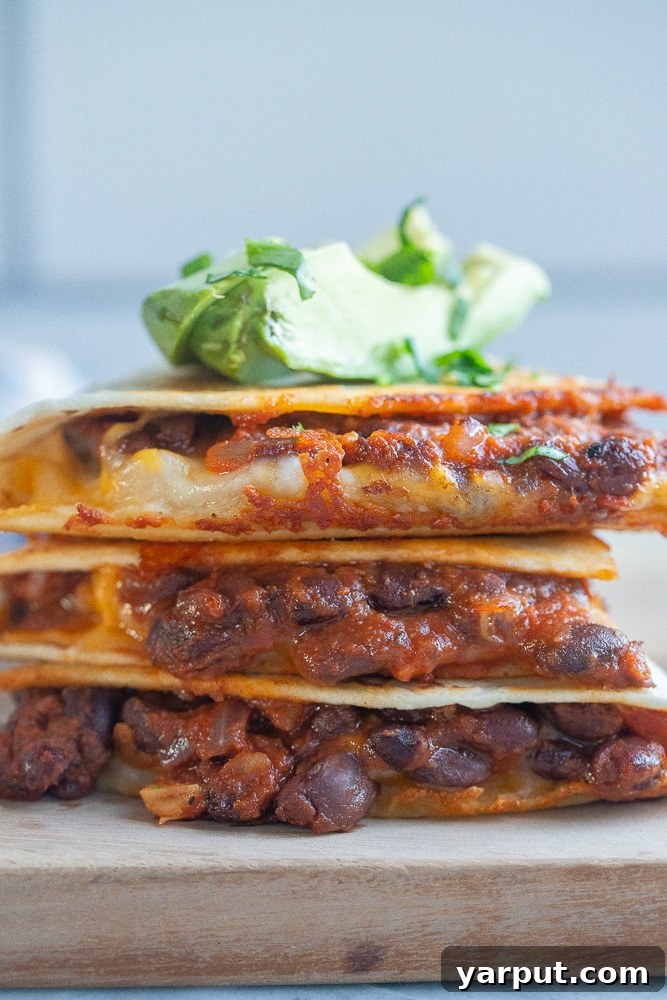 A close-up view of a stack of perfectly cooked BBQ Black Bean Quesadillas, showcasing their crispy exterior and delicious filling.