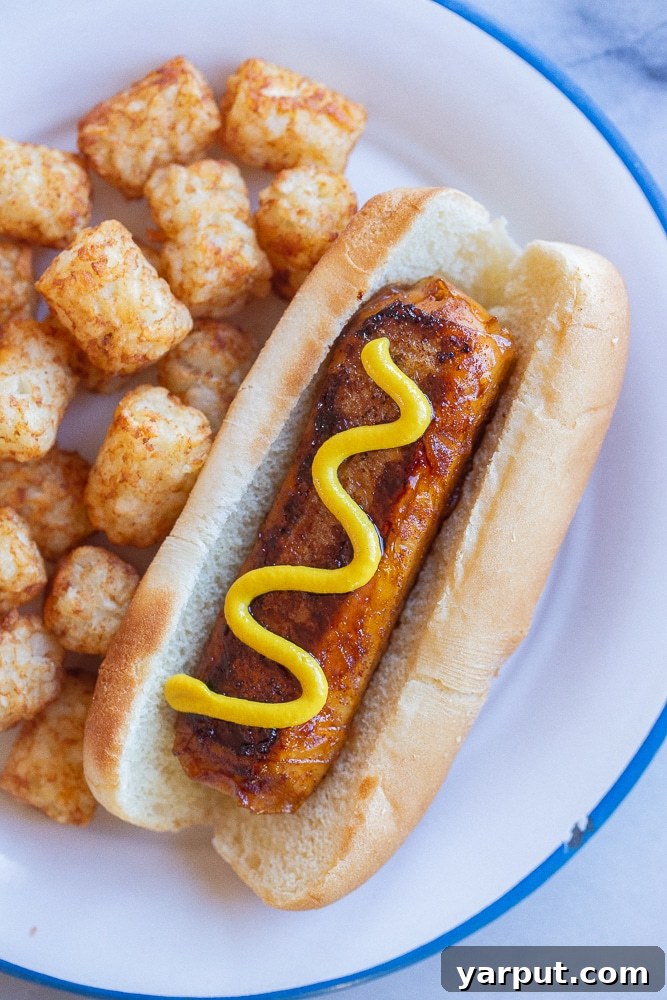 Whip Up Your Own Vegan Hot Dogs 7 vegan hot dog in a bun topped with mustard and tater tots