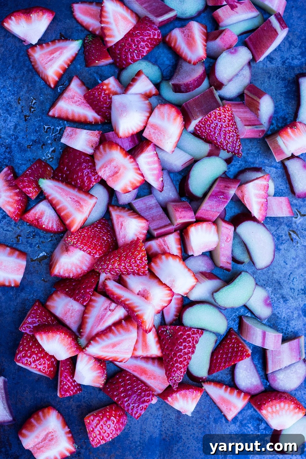 Tangy Strawberry Rhubarb and Lime Pops 4 Chopped strawberries, rhubarb, and lime zest prepared on a large wooden platter, ready for the popsicle mixture