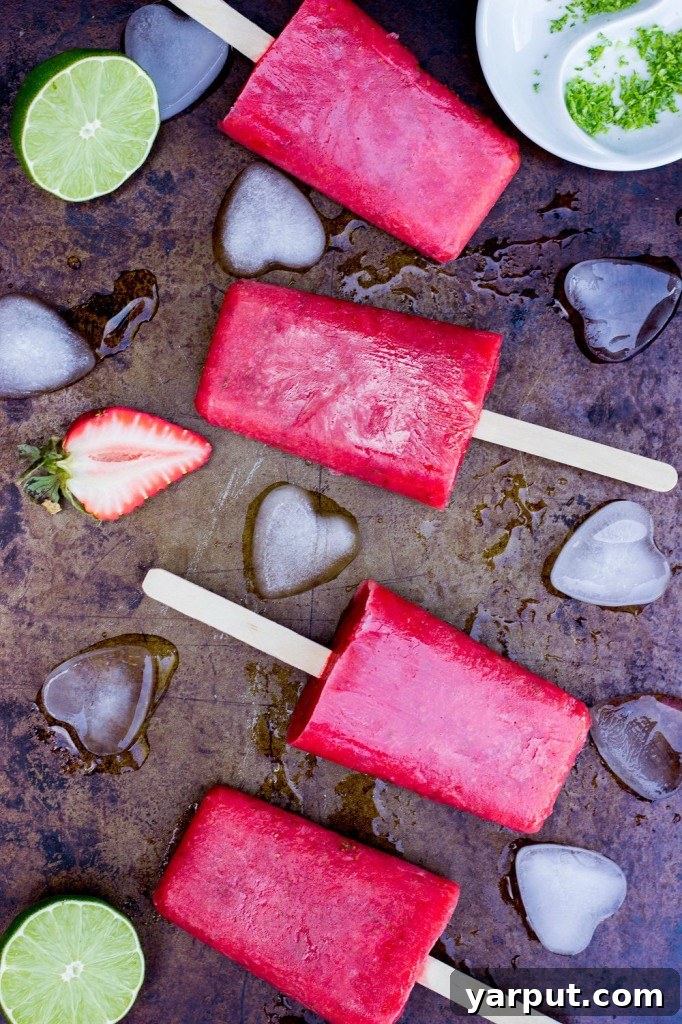 Tangy Strawberry Rhubarb and Lime Pops 8 Artfully arranged Strawberry Rhubarb & Lime Popsicles, stacked on a white plate, highlighting their beautiful color and refreshing appeal