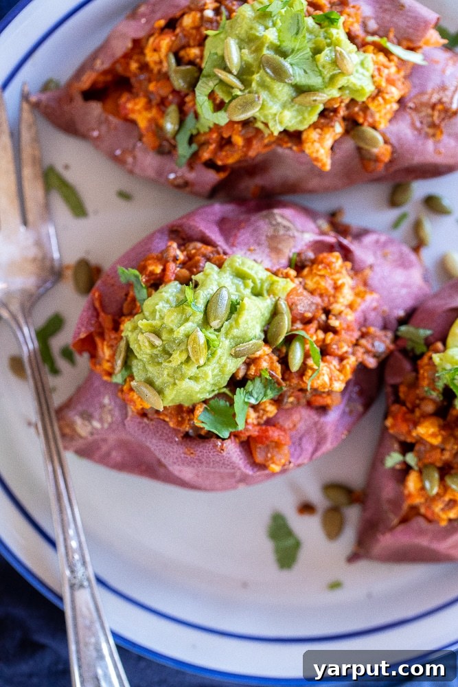 Vibrant Veggie Wellness Week 36 4 Two vibrant sloppy joe stuffed sweet potatoes, generously filled with a rich plant-based mixture and garnished with fresh green onions, a healthy and satisfying vegetarian dinner.