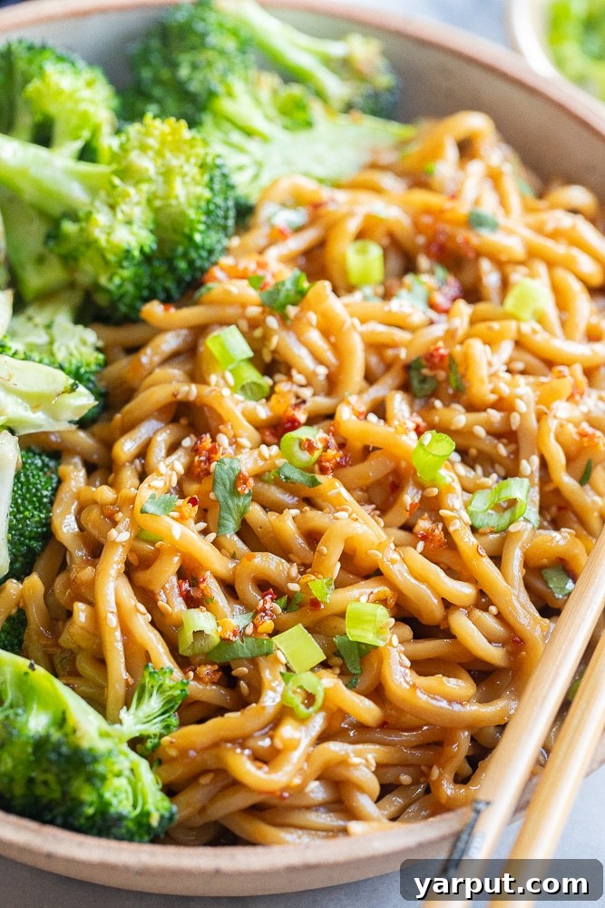 Vibrant Veggie Wellness Week 36 5 A vibrant bowl of sweet and spicy stir-fry noodles, brimming with colorful vegetables like bell peppers, carrots, and snap peas, glistening with sauce.