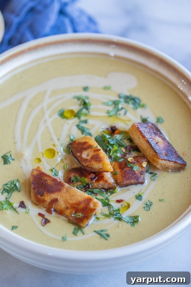 Vegetarian Meal Plan Made Easy: Week 37 4 A bowl of rich Easy Falafel Soup garnished with fresh herbs and served alongside golden crispy pita bread, inviting a comforting meal.