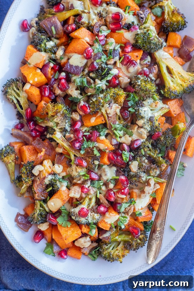 Curry Tahini Drizzled Roasted Sweet Potato and Broccoli 7 A festive serving platter showcasing beautifully roasted sweet potatoes and broccoli with curry tahini sauce, adorned with pomegranate seeds, ideal for a Thanksgiving or holiday meal.