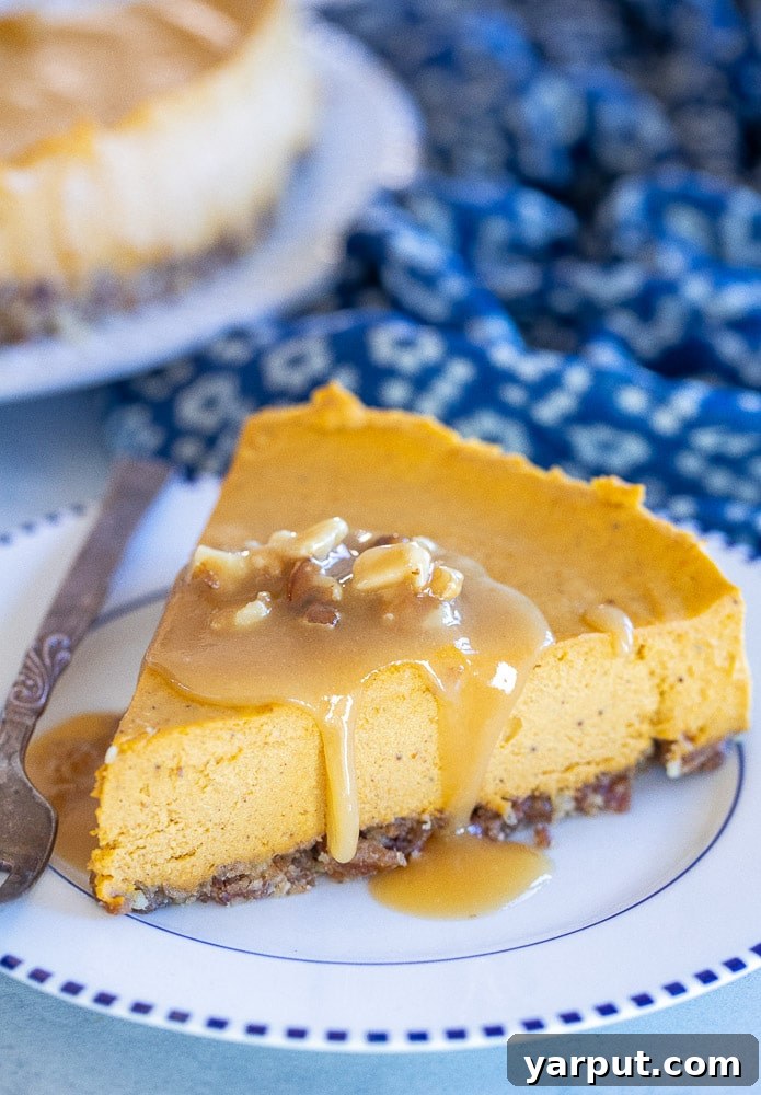 The Ultimate Vegan Thanksgiving Menu and Shopping List 12 A slice of creamy No-Bake Vegan Pumpkin Cheesecake, adorned with a swirl of vegan whipped cream and a sprinkle of cinnamon. The cheesecake looks rich and smooth, set on a graham cracker crust, embodying a perfect fall dessert.