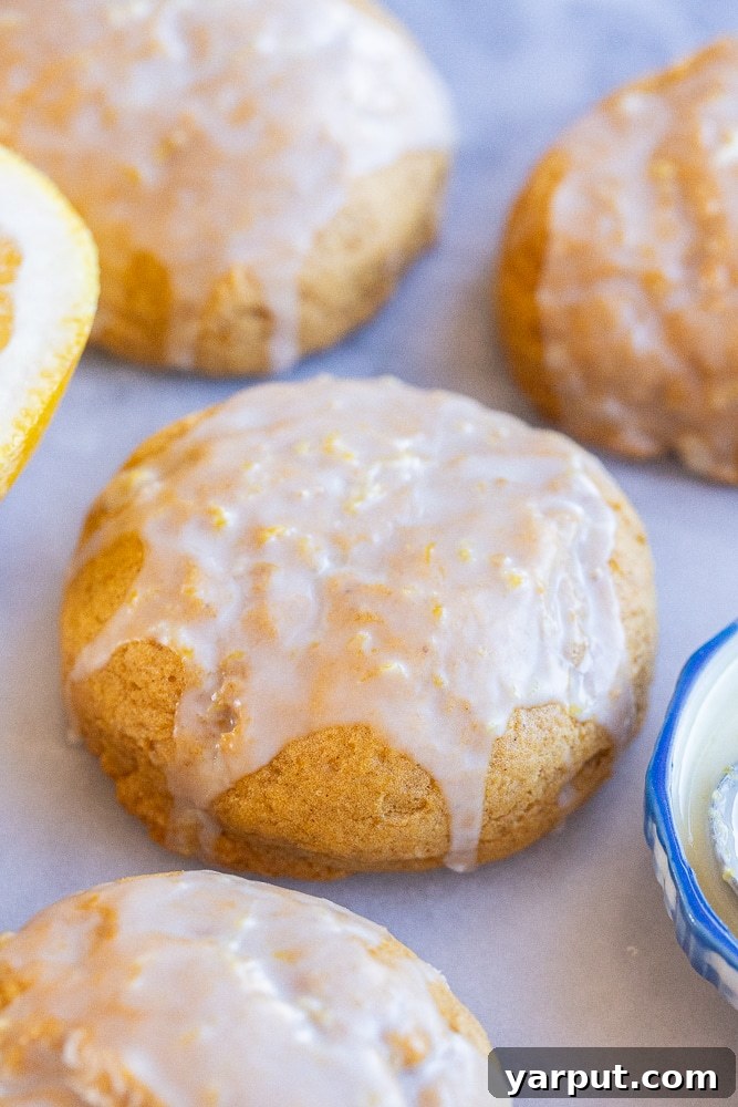 Pillowy Pumpkin Cookies with Zesty Orange Glaze 5 close up of an orange glazed soft pumpkin cookie, showing the texture and vibrant glaze