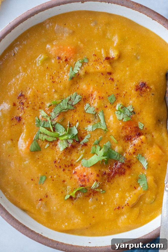 A close-up of a perfectly garnished bowl of vegetarian split pea soup, ready to be enjoyed.