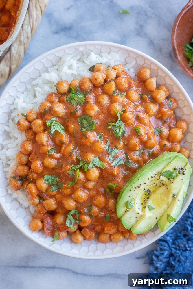 Effortless Vegetarian Eating: Week 2 5 Creamy smoky coconut chickpeas served in a bowl with fluffy white rice, garnished with fresh herbs.