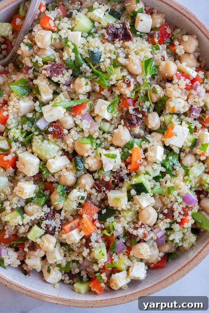 The Ultimate Easy Quinoa Salad 5 A close-up view of a serving bowl filled with easy quinoa salad, highlighting the vibrant colors and fresh textures of the vegetables, quinoa, and chickpeas, ready to be enjoyed.