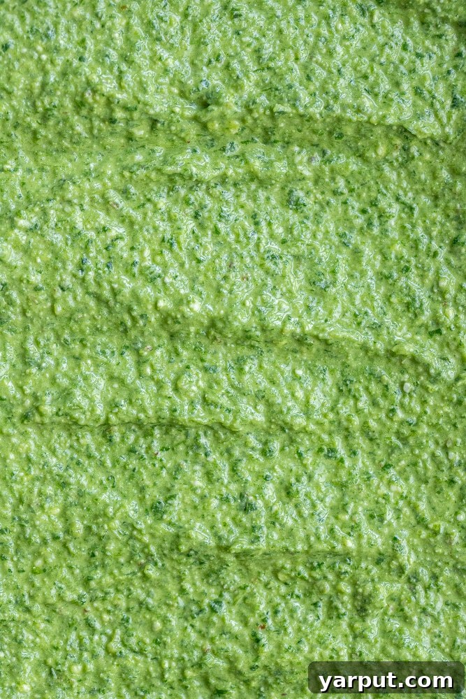 Mediterranean Feta & Spinach Pesto 7 A vibrant close-up of homemade basil pesto with spinach and feta cheese, showcasing its rich texture and inviting green color.