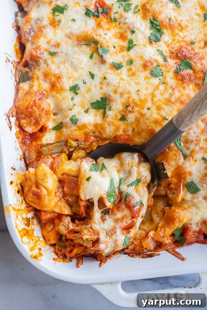Creamy Cheesy Vegetarian Tortellini Bake 6 cheesy tortellini bake with a serving spoon ready to be enjoyed
