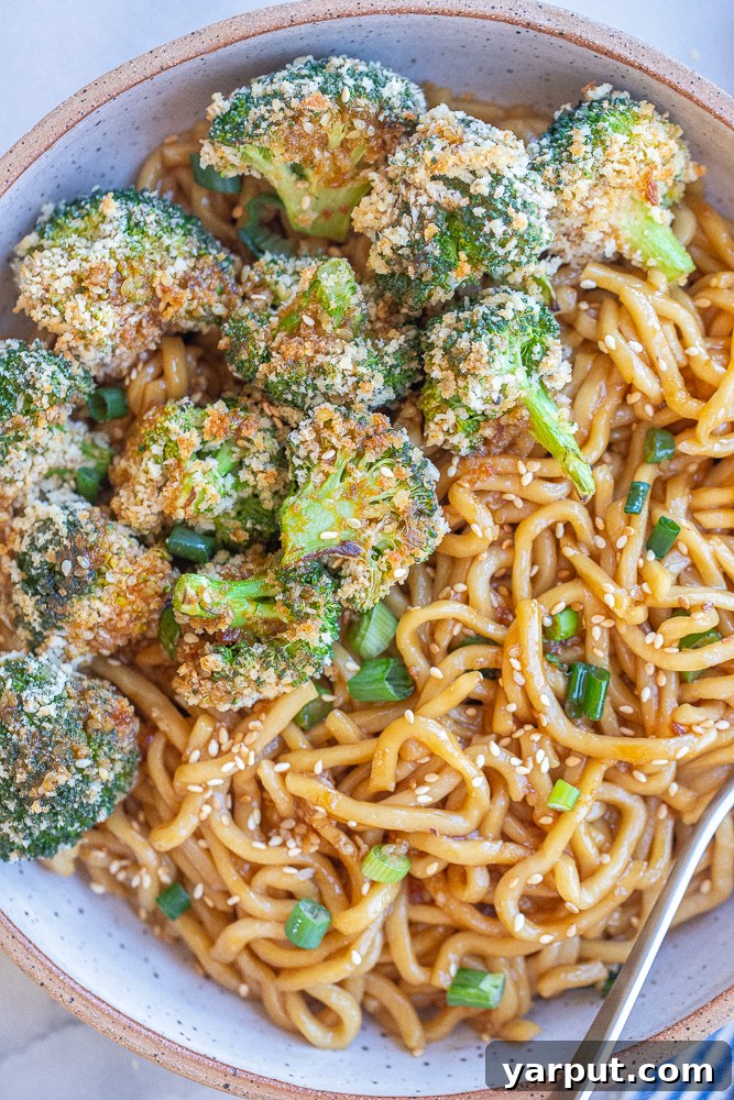 Sticky Teriyaki Noodles with Crispy Roasted Broccoli 7 An inviting close-up of a serving of teriyaki noodles with crispy broccoli, beautifully presented in a bowl, highlighting the texture of the broccoli.