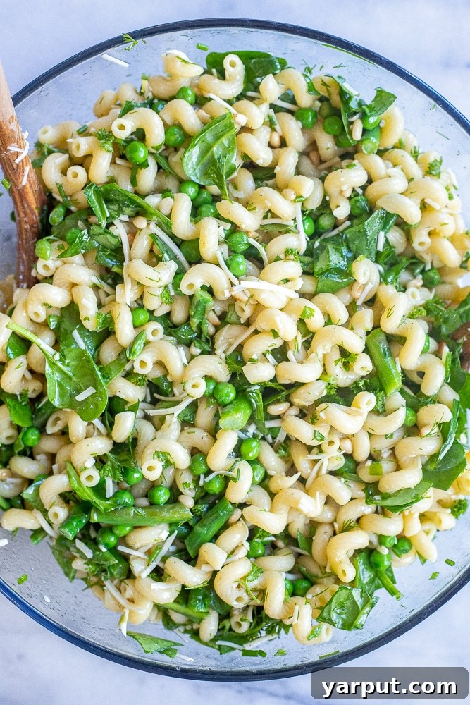 Sunshine Parmesan Spring Pasta Salad 5 veggie packed pasta salad in a large bowl with a serving spoon