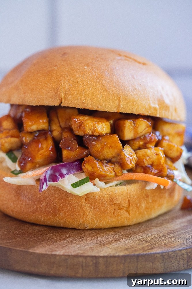 Quick and Delicious BBQ Tofu Sandwiches 6 Close-up of a perfectly assembled Easy BBQ Tofu Sandwich, showcasing the crispy tofu, fresh coleslaw, and soft bun.