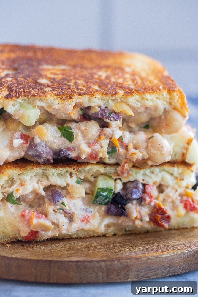 Grecian Chickpea Toasties 6 Close-up of a Greek chickpea melt, highlighting the fresh cucumber slices and Kalamata olives within the filling.