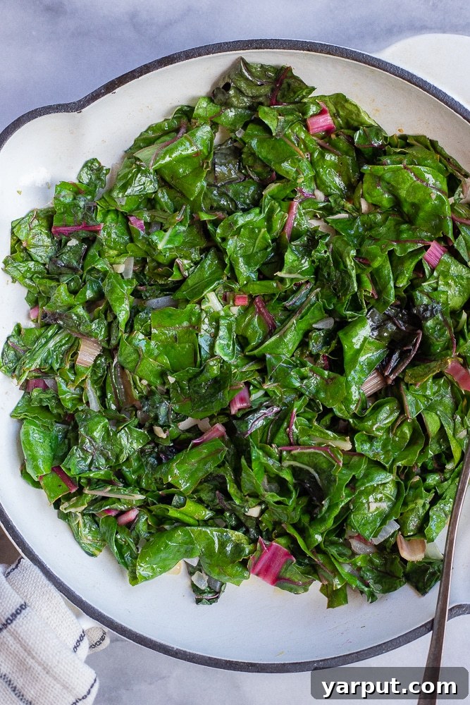 Effortless Swiss Chard Sauté 5 A pan full of freshly cooked, vibrant green easy sautéed Swiss chard, perfectly wilted and ready to be transferred to a serving dish.