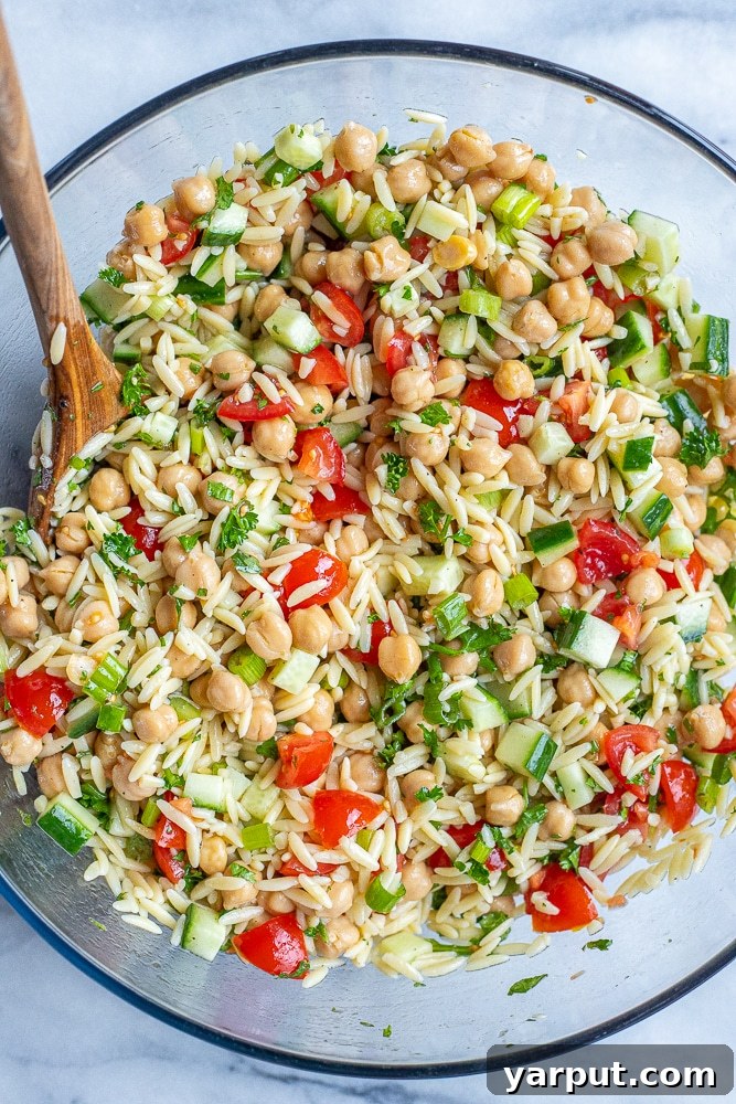 Vibrant Mediterranean Orzo & Chickpea Salad 4 A large, inviting bowl filled with the completed Tabouli Inspired Orzo Salad, showcasing the perfectly mixed orzo, chickpeas, and colorful fresh vegetables.