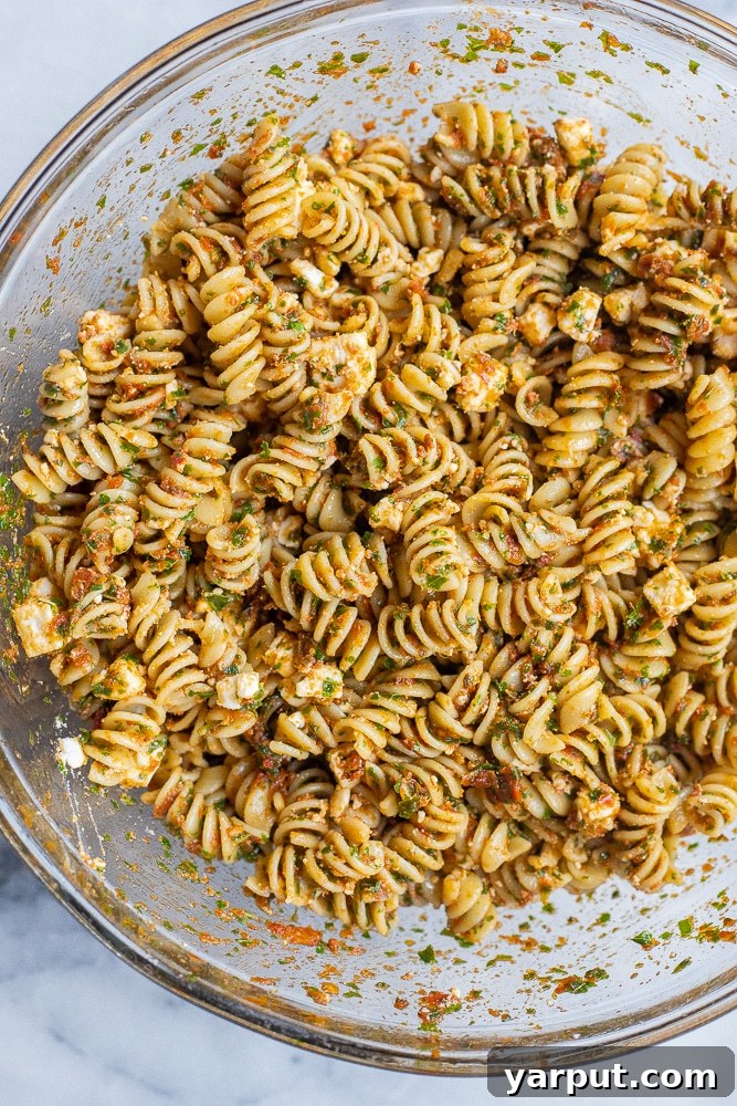 Zesty Sun-Dried Tomato Pasta with Fresh Kale and Feta 5 serving bowl full of vibrant kale and sun-dried tomato pasta with feta cheese, ready to be enjoyed