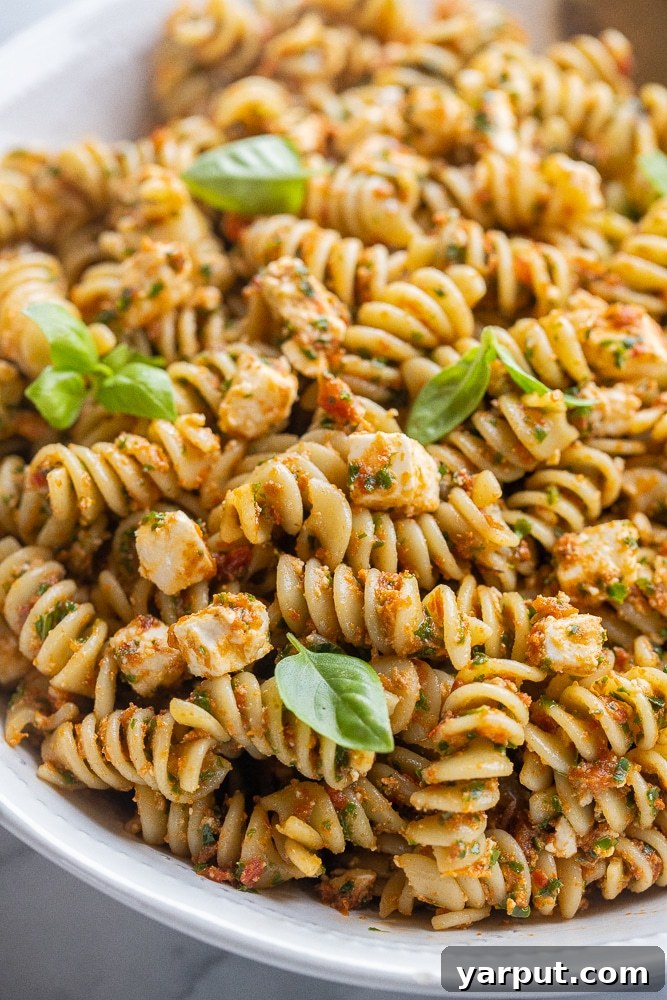 Zesty Sun-Dried Tomato Pasta with Fresh Kale and Feta 6 close up shot of a bowl of kale and sun-dried tomato pasta with fresh basil, showcasing the vibrant colors and textures