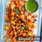 A top-down view of a roasted carrot couscous bowl with a side of lemon parsley tahini sauce, ideal for meal prep.