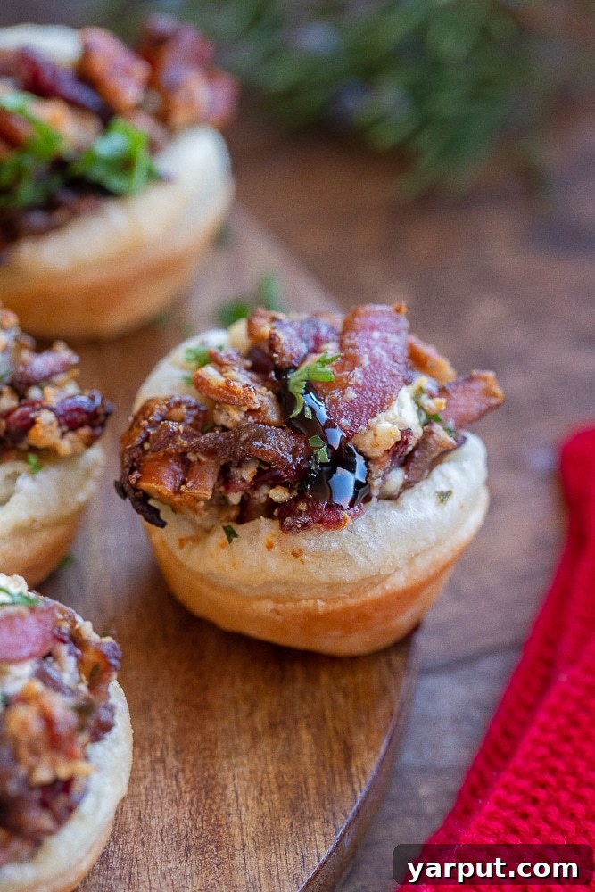Caramelized Balsamic Onion and Goat Cheese Puffs 2 Close-up of a perfectly baked Balsamic Onion and Goat Cheese Puff Pastry Bite on a rustic cutting board, showcasing its golden crust and flavorful filling.