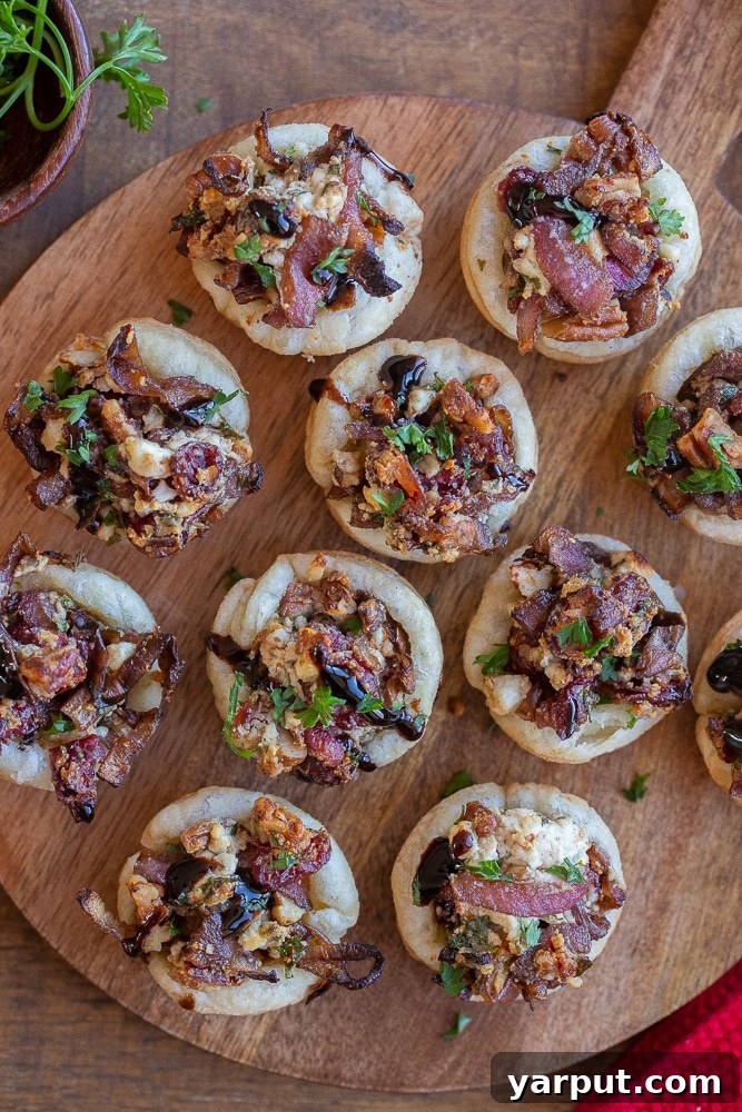 Caramelized Balsamic Onion and Goat Cheese Puffs 6 A festive cutting board adorned with freshly baked Balsamic Onion and Goat Cheese Puff Pastry Bites, ready for serving.