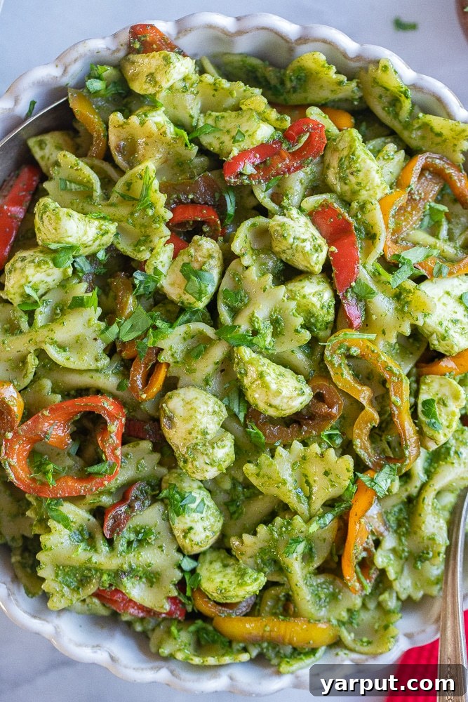 Vibrant Holiday Pesto Pasta Salad 6 A close-up view of the finished holiday pesto pasta salad, showcasing its vibrant colors and delicious textures in a large serving bowl.
