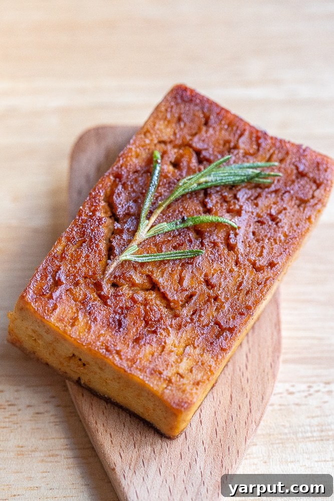 Buttery Garlic Herb Tofu Steaks 6 Close-up of a perfectly cooked vegetarian tofu steak, showing its crispy exterior and tender interior, infused with garlic and herbs
