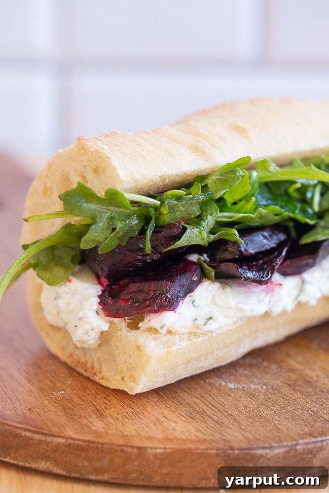 Vibrant Roasted Beet and Zesty Goat Cheese Sandwiches 7 close up of a roasted beet sandwich with horseradish goat cheese and arugula, showing vibrant colors
