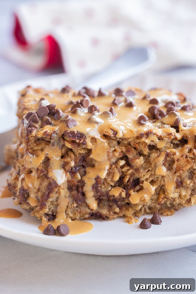 Protein-Packed Baked Oats 2 close up of a slice of high protein baked oatmeal topped with peanut butter and chocolate chips, ready to be enjoyed