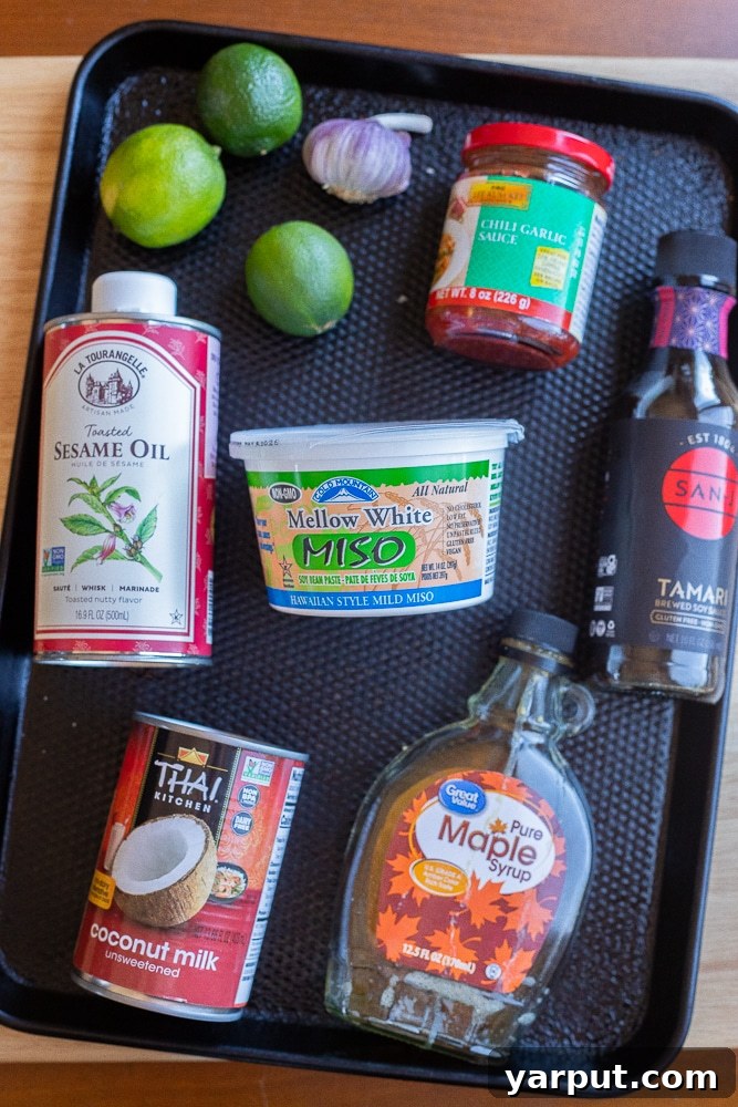 All the fresh ingredients needed to make this easy and delicious coconut lime noodle recipe laid out on a table, including noodles, coconut milk, limes, and spices.