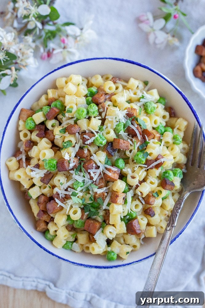 Vegetarian Pasta with Peas and Smokey Veggie Pancetta 7 A beautifully presented bowl of creamy parmesan pasta with peas and crispy tofu 'pancetta,' ready to be enjoyed.